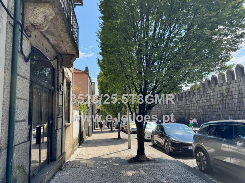 Edifício de 4 pisos com amplo logradouro em frente à muralha de Guimarães